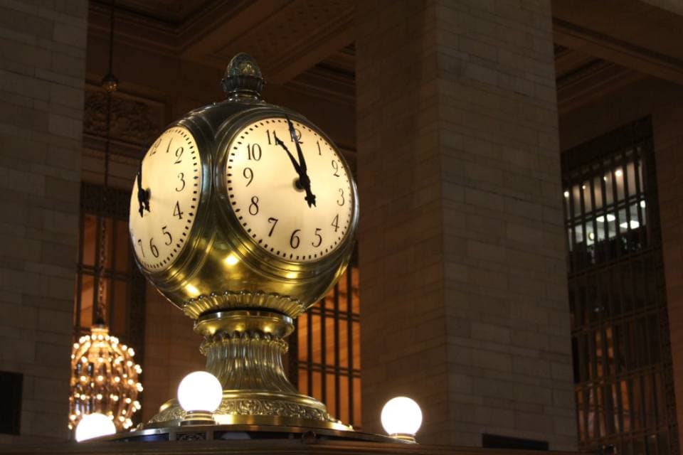 A four-faced brass station clock
